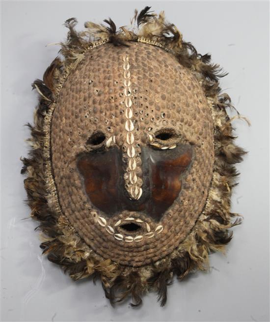A Solomon Islands turtle shell mask, applied with shells and feathers, 41cm
